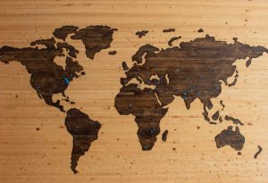 Peta dunia yang digambar pada panel kayu dengan paku payung biru menandai egions tertentu